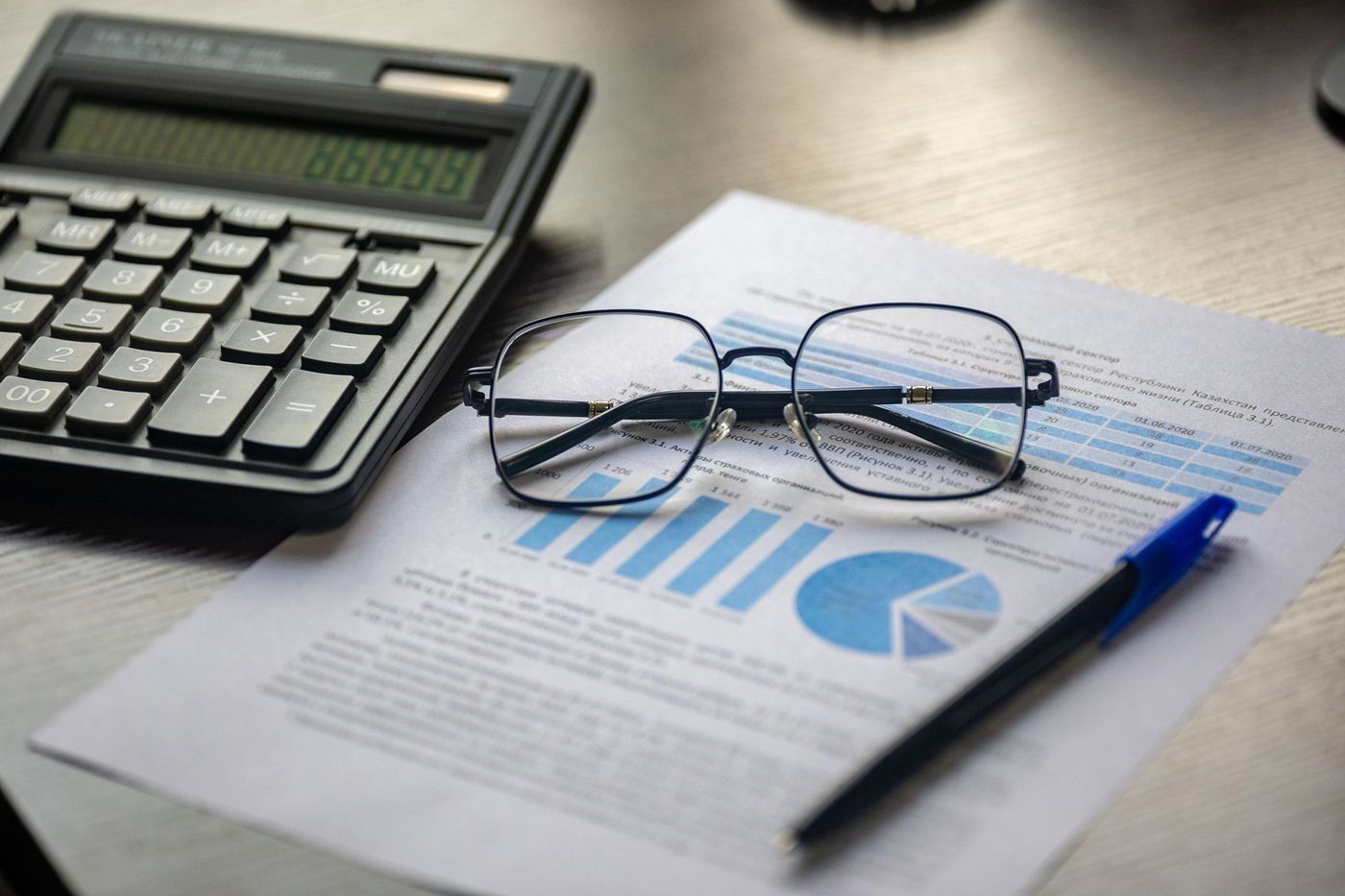 Informe financiero con gráfico y lentes sobre un escritorio